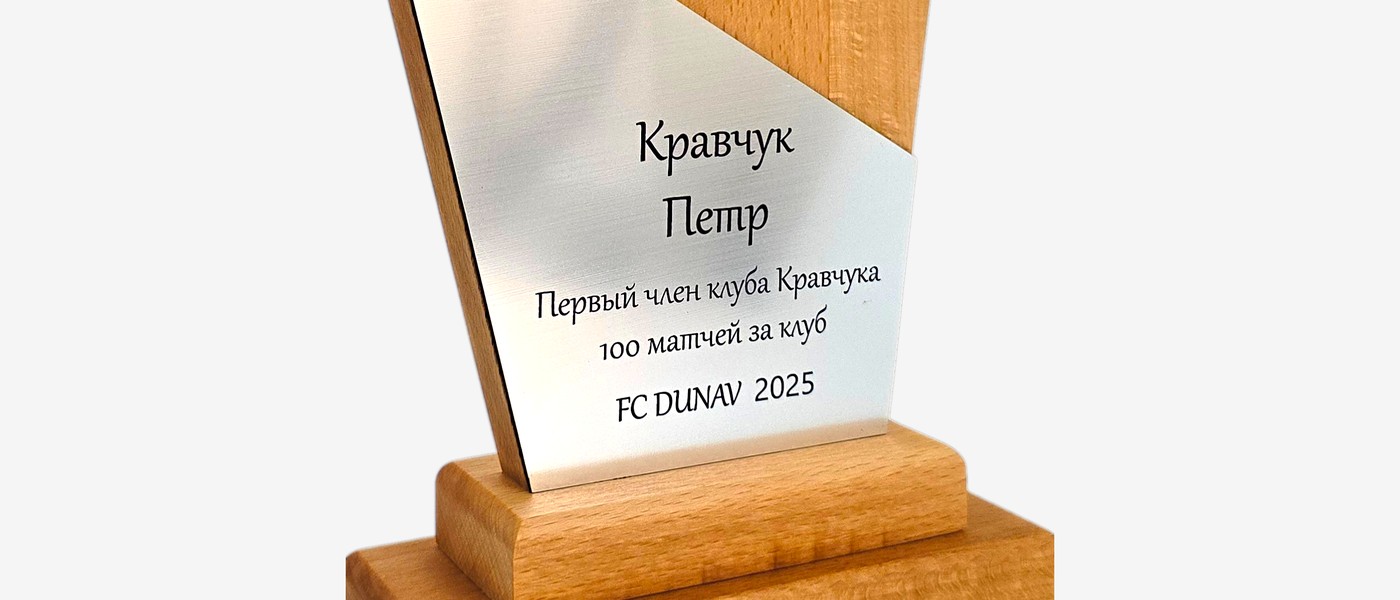 Detalj prirodne teksture drveta sa gravirana srebrnom pločicom na trofeju